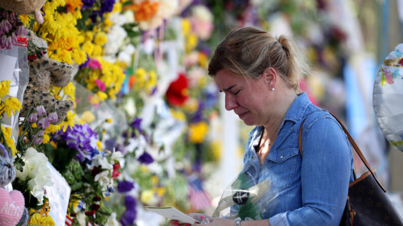 Laura Solla llora mientras coloca flores cerca del sitio conmemorativo para las víctimas del derrumbe del edificio de condominios Champlain Towers South de 12 pisos el 8 de julio de 2021 en Surfside, Florida. (Anna Moneymaker/Getty Images)