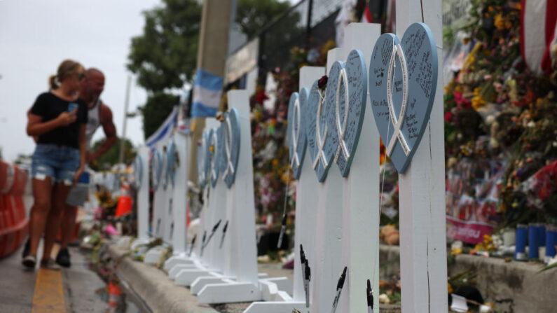 La gente visita el monumento a las víctimas del edificio de condominios Champlain Towers South que se derrumbó tras una fuerte tormenta el 12 de julio de 2021 en Surfside, Florida (EE.UU.). (Anna Moneymaker/Getty Images)