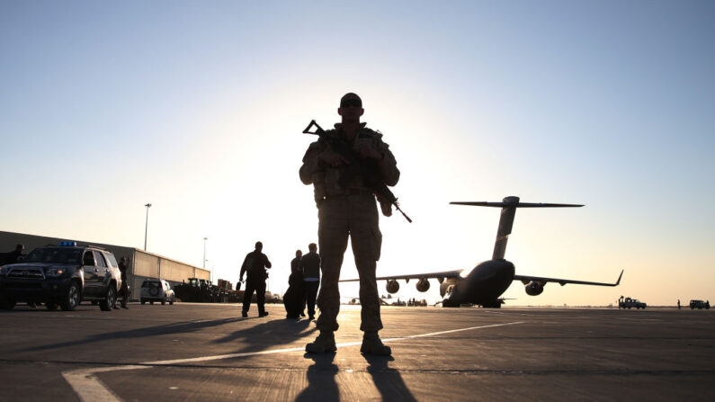 Un soldado hace guardia cerca de un avión militar C17 ubicado en la pista, el 8 de diciembre de 2013, en Kandahar, Afganistán. (Mark Wilson/Getty Images)