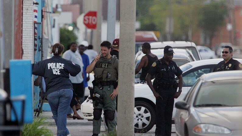 Agentes federales, junto con la policía de Miami y otros agentes de la ley, llevan a cabo lo que se considera una investigación relacionada con el terrorismo cerca de los proyectos de viviendas Scott en la zona de la 15ª avenida y la calle 62 del noroeste, el 22 de junio de 2006, en el barrio Liberty City de Miami, Florida. (Joe Raedle/Getty Images)