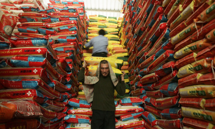 Trabajadores chinos descargan arroz en un mercado de productos agrícolas, el 8 de abril de 2008 en Wuhan, provincia de Hubei, China. (Fotos de China/Getty Images)