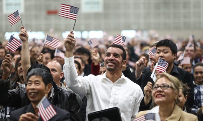 Nuevos ciudadanos estadounidenses ondean banderas de EE.UU. en una ceremonia de naturalización en Los Ángeles el 20 de marzo de 2018. (Mario Tama/Getty Images)