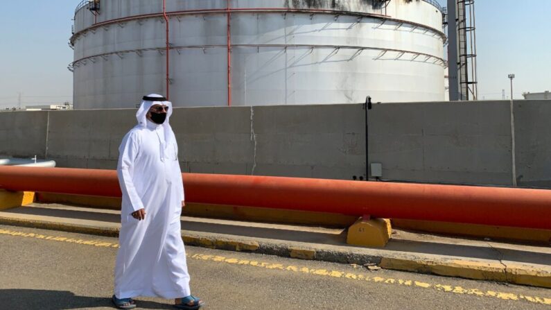 Un hombre, usando una mascarilla por la pandemia del COVID-19, pasa frente a un silo dañado en la instalación petrolera de Saudi Aramco en la ciudad de Jeddah en el Mar Rojo de Arabia Saudita, el 24 de noviembre de 2020. (Fayez Nureldine/AFP a través de Getty Images)