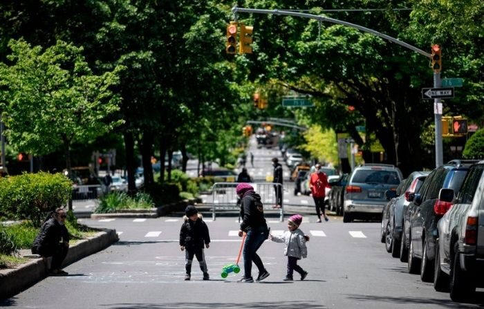 
Una mujer juega con dos niños en una calle, el 13 de mayo de 2020 en el barrio de Queens de la ciudad de Nueva York. Imagen ilustrativa.(JOHANNES EISELE/AFP vía Getty Images)