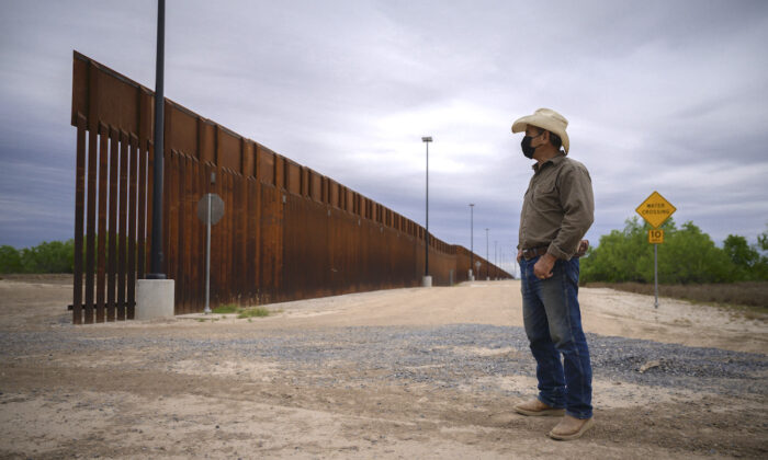 El propietario de un rancho se encuentra frente a una parte del muro fronterizo sin terminar que el expresidente de Estados Unidos, Donald Trump, intentó construir, cerca de Roma, Texas, el 28 de marzo de 2021. (Ed Jones/AFP a través de Getty Images)