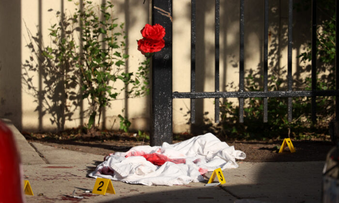 Una sábana empapada de sangre se encuentra entre los marcadores de evidencia después de un tiroteo en el que tres personas fueron baleadas en el complejo de viviendas Wentworth Gardens en el barrio de Bridgeport en Chicago, Illinois, el 23 de junio de 2021. (Scott Olson/Getty Images)