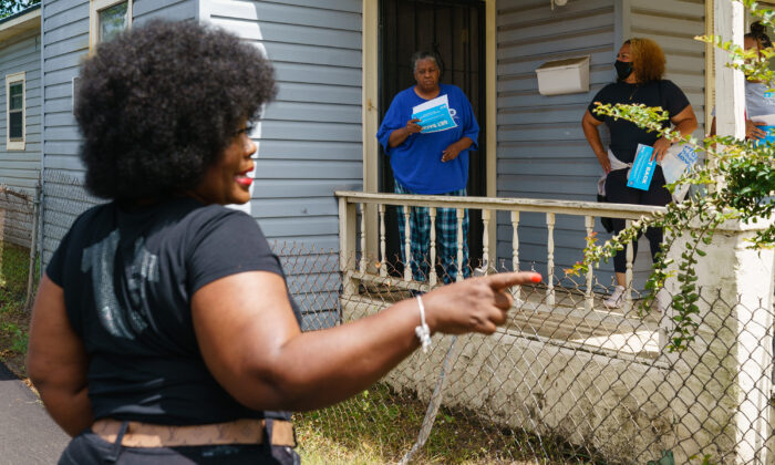 La comisionada del condado de Jefferson, Sheila Tyson (Izq.), acompaña a los voluntarios y al personal durante un esfuerzo de divulgación de puerta en puerta para informar a los residentes sobre un próximo evento de vacunación contra la COVID-19 en Birmingham, Alabama, el 30 de junio de 2021. (Elijah Nouvelage/AFP a través de Getty Images)