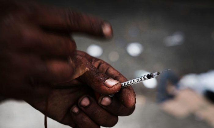 Un consumidor de heroína muestra una aguja en un barrio del sur del Bronx que tiene el mayor índice de muertes por sobredosis relacionadas con la heroína en la ciudad de Nueva York, el 6 de octubre de 2017. (Spencer Platt/Getty Images)