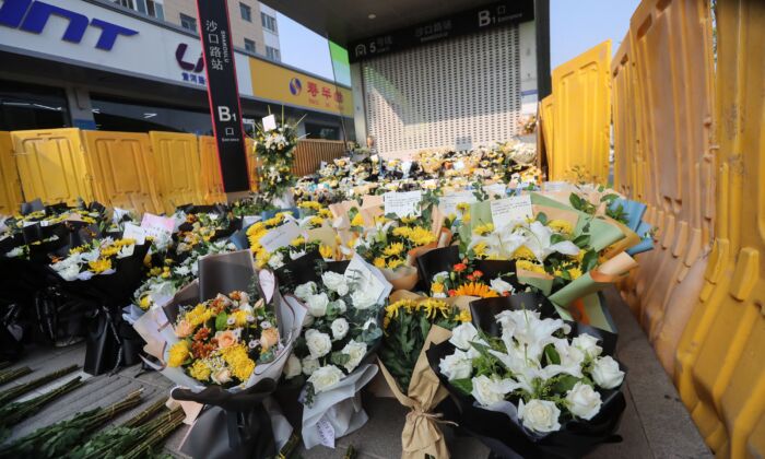 Flores colocadas como homenajes se ven delante de una estación de metro en memoria de las víctimas de las inundaciones en Zhengzhou, provincia de Henan, en el centro de China, el 27 de julio de 2021. (STR/AFP vía Getty Images)