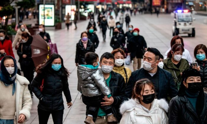 Personas con mascarillas protectoras caminan por una calle de Shanghai, China, el 21 de febrero de 2020. (NOEL CELIS/AFP vía Getty Images)