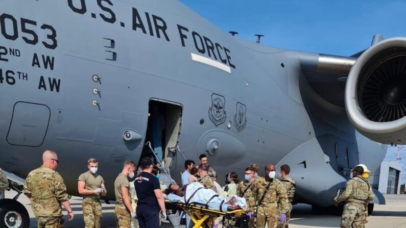 El personal de apoyo médico del 86º Grupo Médico ayuda a una madre afgana a bajar de un C-17 de la Fuerza Aérea de EE.UU. momentos después de dar a luz a una niña a bordo del avión al aterrizar en la Base Aérea de Ramstein, Alemania, el 21 de agosto. (Sargento Técnico Zachary Boyer/Fuerza Aérea de EE.UU.)