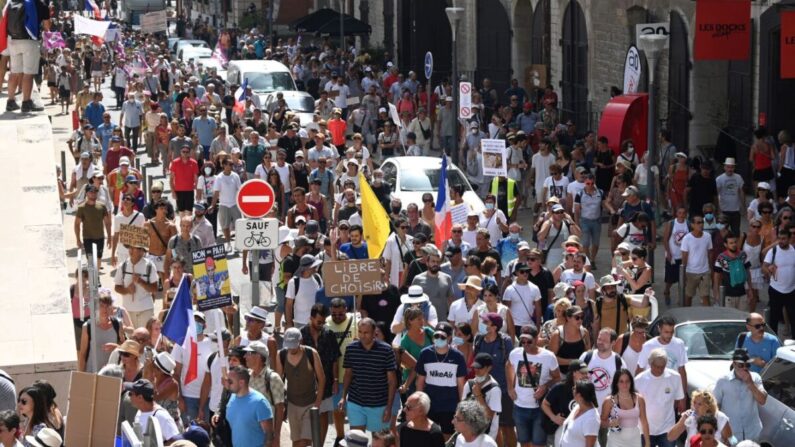 Manifestantes marchan durante un día nacional de protesta contra la vacunación obligatoria del COVID-19 para ciertos trabajadores y contra los pasaportes de vacunas. (Sylvian Thomas/AFP a través de Getty Images)