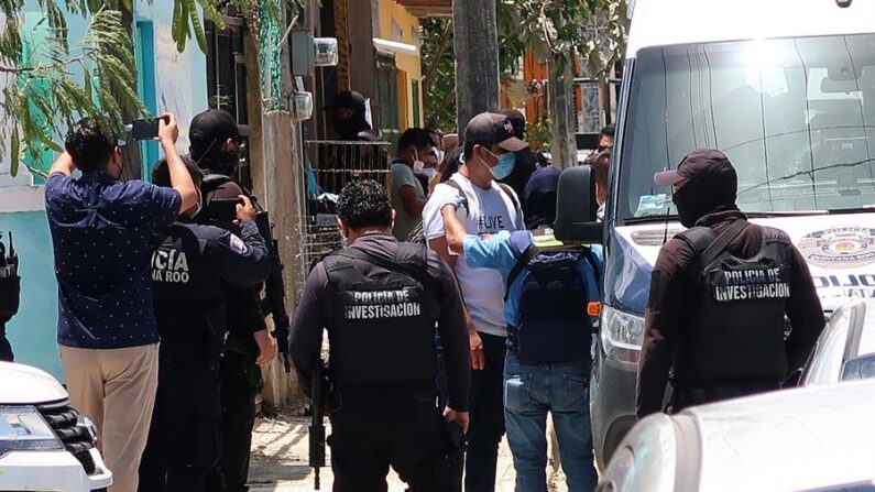 Agentes de la Policía Ministerial de la Fiscalía General Estatal de México escoltan a un grupo de migrantes asegurados en una casa de la ciudad de Cancún, estado de Quintana Roo (México). EFE/Alonso Cupul