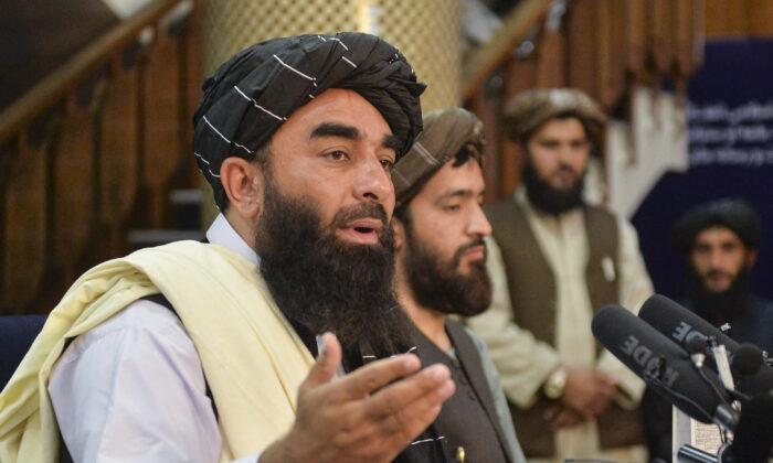 El portavoz talibán Zabihullah Mujahid (i) gesticula mientras habla durante la primera conferencia de prensa en Kabul el 17 de agosto de 2021 tras la sorprendente toma de Afganistán por los talibanes. (Hoshang Hashimi/AFP a través de Getty Images)