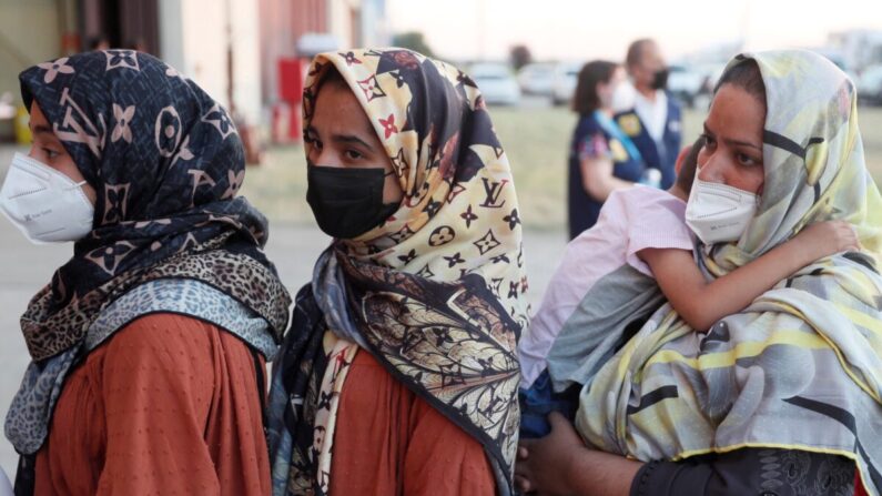 Mujeres afganas hacen fila a su llegada a bordo de un segundo avión de evacuación, que transportaba colaboradores afganos y sus familias, y que aterrizó en la base aérea de Torrejón de Ardoz, a 30 km de Madrid, el 20 de agosto de 2021. (Mariscal/ POOL/ AFP vía Getty Images)