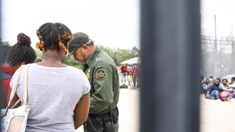 Un agente de la Patrulla Fronteriza comienza a organizar un grupo de más de 350 inmigrantes ilegales después de que cruzaron el río Bravo desde México a Del Río, Texas, el 25 de julio de 2021 (Charlotte Cuthbertson / The Epoch Times).