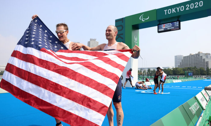 Brad Snyder y el guía Greg Billington del equipo de Estados Unidos reaccionan al cruzar la línea de meta para ganar la medalla de oro durante el triatlón PTVI masculino el día 4 de los Juegos Paralímpicos de Tokio 2020 en el Parque Marino de Odaiba, el 28 de agosto de 2021 en Tokio, Japón. (Lintao Zhang/Getty Images)