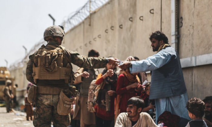 Un marine de EE. UU. reparte agua durante la evacuación en el aeropuerto internacional Hamid Karzai en Kabul (Afganistán) el 21 de agosto de 2021. (Infantería de Marina de EE. UU./Isaiah Campbell/Getty Images)