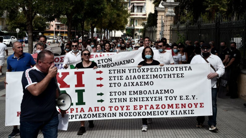 Miembros del sindicato del personal de los hospitales públicos griegos (POEDIN) gritan consignas durante una manifestación para protestar por la vacunación obligatoria de los trabajadores sanitarios contra el covid-19, en Tesalónica (Grecia) el 26 de agosto de 2021. (Sakis Mitrolidis/AFP vía Getty Images)