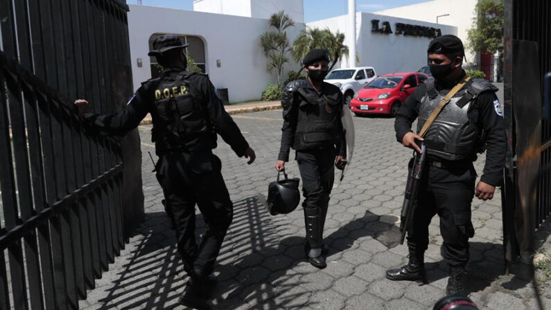 Miembros de la policía permanecen en la entrada de una propiedad de la Editorial La Prensa durante un operativo de allanamiento, el 13 de agosto de 2021, en Managua (Nicaragua). EFE/Jorge Torres