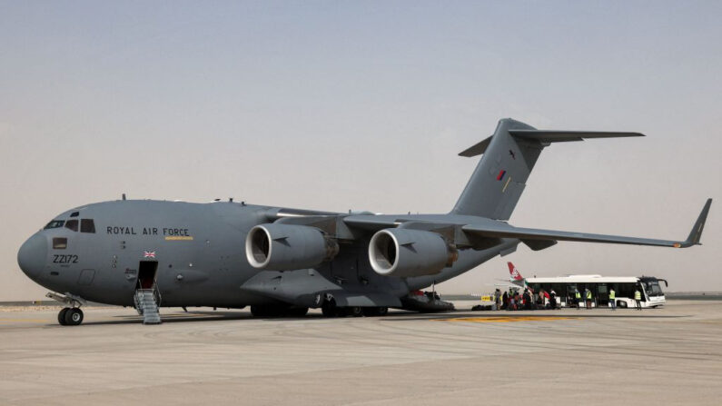 Un grupo de personas desembarca de un avión de transporte militar Boeing C-17A Globemaster III de la Real Fuerza Aérea que transporta a los evacuados de Afganistán y que llega al aeropuerto internacional de Al-Maktoum, en los Emiratos Árabes Unidos, el 19 de agosto de 2021. (Giuseppe Cacace/AFP vía Getty Images)