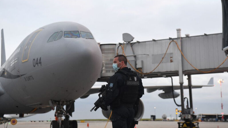 Un gendarme francés hace guardia frente al avión Airbus A330 de la Fuerza Aérea francesa en la pista después de que los pasajeros, que huyeron de Afganistán, desembarquen en el aeropuerto Roissy Charles-de-Gaulle, al norte de la capital francesa, el 18 de agosto de 2021. (Alain Jocard/AFP vía Getty Images)