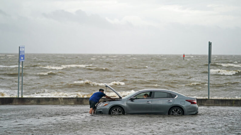 Un hombre ayuda a un automovilista varado en las aguas de la inundación en Beach Blvd. el 30 de agosto de 2021 en Biloxi, Mississippi. La tormenta tropical Ida tocó tierra como huracán de categoría 4 ayer en Louisiana y provocó inundaciones y daños por viento a lo largo de la costa del Golfo. (Sean Rayford/Getty Images)