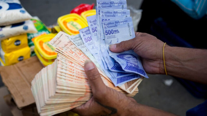 Un hombre sostiene billetes de Bolívar en un mercado callejero en el barrio de Catia, en Caracas (Venezuela), el 6 de abril de 2021. (Pedro Rances Mattey/AFP vía Getty Images)