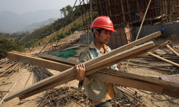 Un trabajador chino transporta materiales para la primera línea ferroviaria que une China con Laos, una parte clave de la 'Iniciativa de la Franja y la Ruta' de Beijing a través del Mekong, en Luang Prabang, Laos, el 8 de febrero de 2020. (Aidan Jones/AFP a través de Getty Images)