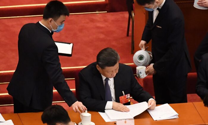 Asistentes sirven té para el presidente chino, Xi Jinping, durante la sesión inaugural de una conferencia de la legislatura títere, en el Gran Salón del Pueblo, en Beijing, China, el 22 de mayo de 2020. (LEO RAMIREZ/AFP a través de Getty Images)