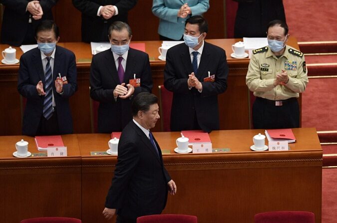 Los altos funcionarios aplauden al líder chino Xi Jinping cuando llega a la sesión de clausura de la conferencia legislativa títere del régimen en el Gran Salón del Pueblo en Beijing, China, el 28 de mayo de 2020 (Nicolas Asfouri/AFP a través de Getty Images).