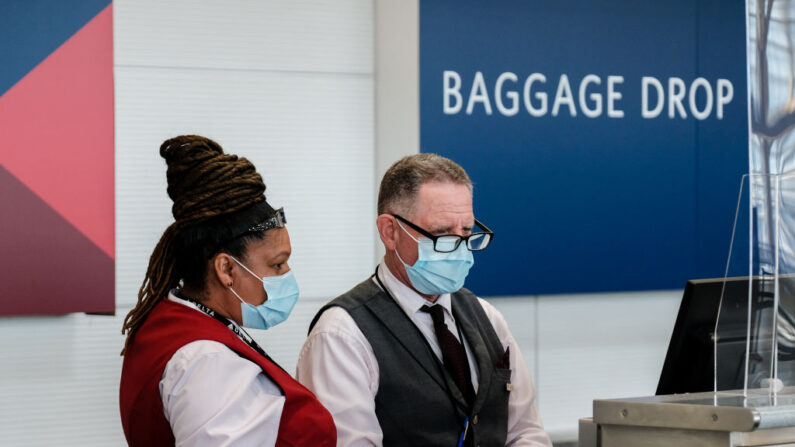 Los empleados de la aerolínea Delta facturan el equipaje en el Aeropuerto Nacional Ronald Reagan el 22 de julio de 2020 en Arlington, Virginia. (Michael A. McCoy/Getty Images)