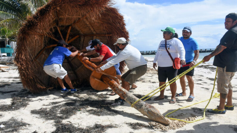 En una foto de archivo, trabajadores retiran una sombrilla en preparación para la llegada del huracán Delta, en Puerto Morelos, estado de Quintana Roo, México, el 6 de octubre de 2020. (Elizabeth Ruiz/AFP vía Getty Images)