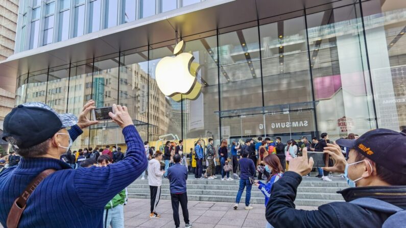 Los clientes hacen fila para obtener sus teléfonos móviles iPhone 12 reservados en una tienda Apple de Shanghai, el 23 de octubre de 2020. (STR/AFP a través de Getty Images).