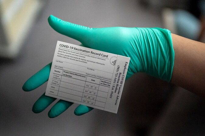 Un trabajador sanitario muestra una tarjeta de registro de la vacuna COVID-19 en el Centro Médico de Asuntos de Veteranos de Portland el 16 de diciembre de 2020 en Portland, Oregon. (Nathan Howard/Getty Images)