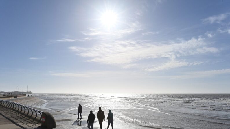 La gente disfruta del sol mientras camina por la playa en Blackpool, Lancashire, Reino Unido, el 16 de marzo de 2021. (Paul Ellis/AFP vía Getty Images)