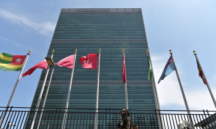 Una persona pasa junto a las banderas frente a la sede de las Naciones Unidas en la ciudad de Nueva York el 20 de mayo de 2021. (Angela Weiss/AFP a través de Getty Images)