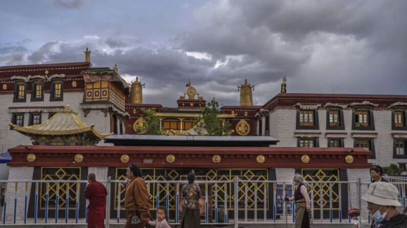 Budistas tibetanos caminan la kora frente al templo de Jokhang, patrimonio de la UNESCO, el 1 de junio de 2021 en Lhasa, región del Tíbet, China. Recientemente se han relajado las restricciones de viaje para los extranjeros en un intento de impulsar el turismo en el Tíbet. El régimen chino pretende conseguir 61 millones de visitantes anuales para 2025, más de 15 veces el número de habitantes del Tíbet. (Kevin Frayer/Getty Images)