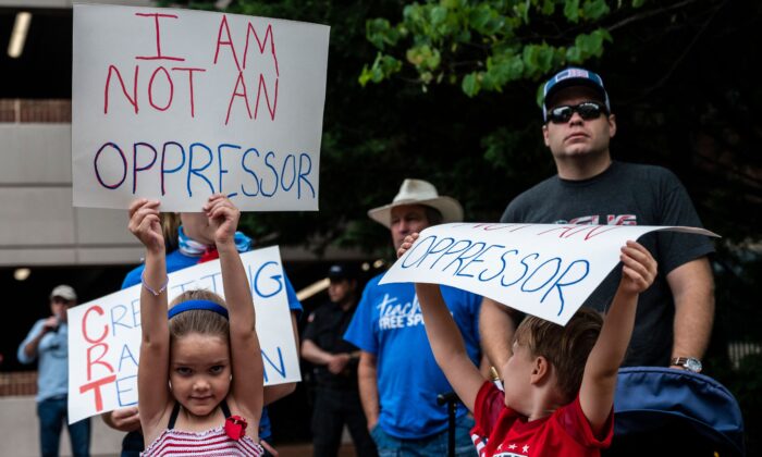 Niños sostienen carteles durante una manifestación contra la teoría crítica de la raza, en el condado de Loudoun, Virginia, el 12 de junio de 2021. (Andrew Caballero-Reynolds/AFP a través de Getty Images)