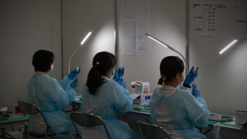 El personal médico prepara jeringas de la vacuna Moderna en un centro de vacunación, el 30 de junio de 2021, en Tokio, Japón. (Carl Court/Getty Images)