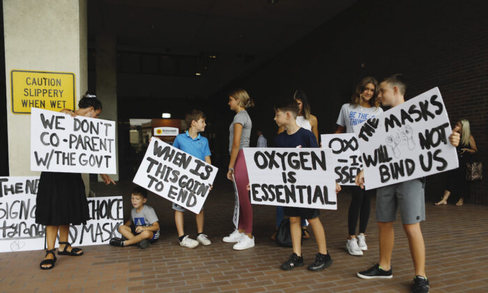 Unas familias protestan contra cualquier posible uso obligatorio de mascarilla antes de la reunión de la Junta Escolar del Condado de Hillsborough en la oficina del distrito el 27 de julio de 2021 en Tampa, Florida. (Octavio Jones/Getty Images)