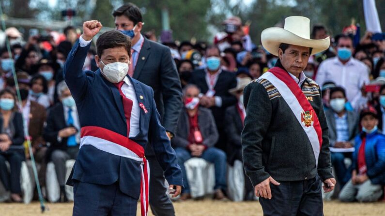 El nuevo Jefe de Estado Mayor de Perú, Guido Bellido (i), levanta el puño junto al presidente de Perú, Pedro Castillo (d), en la Pampa de la Quinua, en Ayacucho, sur de Perú, el 29 de julio de 2021. (Ernesto Benavides/AFP vía Getty Images)