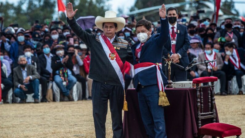 El presidente peruano Pedro Castillo (i) y su primer ministro Guido Bellido (d) saludan en Pampa de la Quinua en Ayacucho, sur de Perú, el 29 de julio de 2021. (Ernesto Benavides/AFP vía Getty Images)