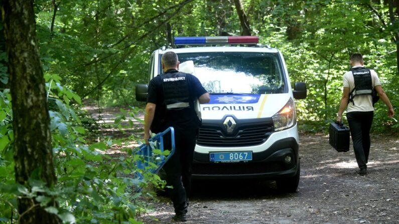 Expertos policiales abandonan el lugar donde Vitaly Shishov, director de la ONG Casa Bielorrusa en Ucrania, fue encontrado ahorcado en un parque, cerca de la capital, Kiev, el 3 de agosto de 2021. (Sergei Supinsky/AFP vía Getty Images)
