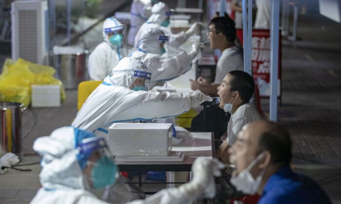 Residentes de Wuhan reciben pruebas de ácido nucleico para COVID-19, en la provincia central de Hubei, China, el 3 de agosto de 2021. (STR/AFP a través de Getty Images)