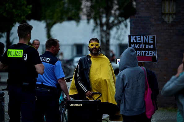 La policía expulsa a manifestantes contra la vacuna COVID-19 quienes protestan afuera del centro de vacunación Arena Treptow, donde la gente llega para recibir una vacuna contra el coronavirus (COVID-19) durante una larga noche de vacunación con música, en Berlín el 9 de agosto de 2021. (Foto de JOHN MACDOUGALL/AFP a través de Getty Images)