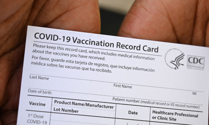 Un trabajador de la salud muestra una tarjeta de registro de vacunación contra COVID-19 durante una clínica de salud y vacunas en QueensCare Health Center en un vecindario predominantemente latino en Los Ángeles, California, el 11 de agosto de 2021. (Robyn Beck/AFP a través de Getty Images)
