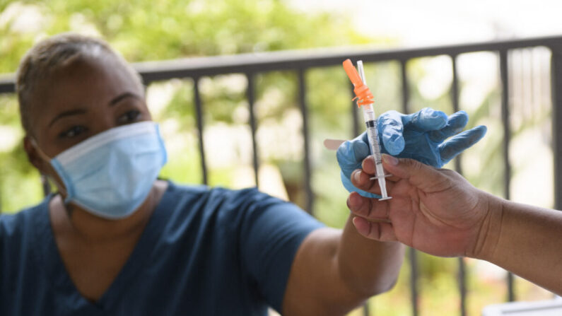Una enfermera recibe una dosis de la vacuna anti-COVID de Pfizer antes de administrarla a un estudiante universitario en una clínica de vacunación móvil, en el campus de la Universidad Estatal de California, en Long Beach, California, el 11 de agosto de 2021. (Patrick T. Fallon/AFP vía Getty Images)