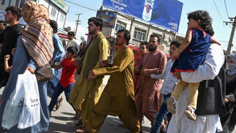 Afganos corren hacia el aeropuerto de Kabul para salir de la ciudad el 16 de agosto de 2021, tras un final sorprendentemente rápido de la guerra de 20 años en Afganistán. (Wakil Kohsar / AFPvía Getty Images)