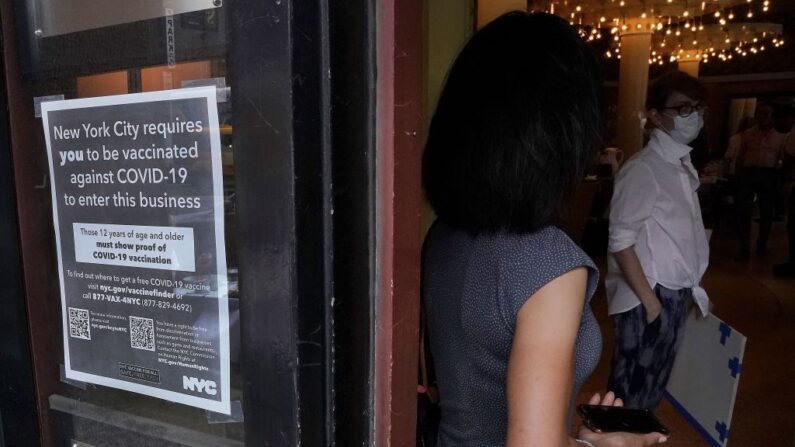 Una mujer espera para entrar en un restaurante del Upper West Side de Nueva York el 17 de agosto de 2021, el primer día en el que hay que demostrar que se tiene la vacuna contra covid-19 para entrar a interiores. (Timothy A. ClaryY/AFP vía Getty Images)